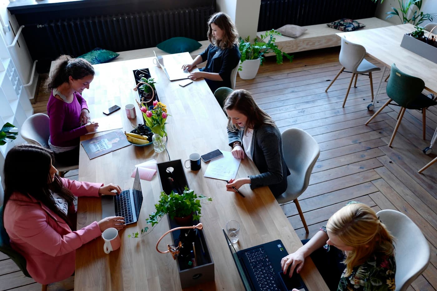 Klein team in overleg aan een houten tafel op kantoor